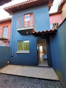 een blauw gebouw met een balkon erboven bij Sobradinho Morro das Pedras in Florianópolis