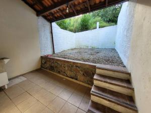 een lege kamer met een bakstenen muur en een trap bij Sobradinho Morro das Pedras in Florianópolis