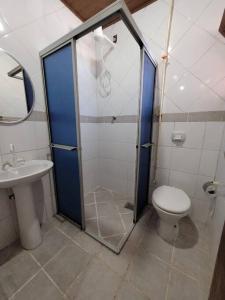 een badkamer met een douche, een toilet en een wastafel bij Sobradinho Morro das Pedras in Florianópolis
