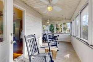 a porch with chairs and a table and windows at The Answer in Edisto Island
