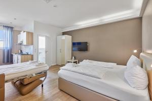 ein Schlafzimmer mit einem großen weißen Bett und einer Küche in der Unterkunft Boardinghotel Heidelberg in Heidelberg