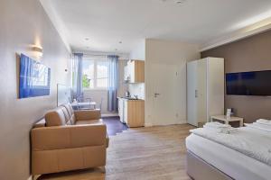 ein Schlafzimmer mit einem Bett und einem Sofa sowie eine Küche in der Unterkunft Boardinghotel Heidelberg in Heidelberg