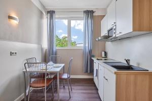 eine Küche mit Tisch und Stühlen und einem Fenster in der Unterkunft Boardinghotel Heidelberg in Heidelberg + 16 Fotos
