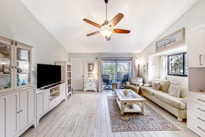 a living room with a couch and a tv at Ocean’s Treasures Retreat Beach Condo in Ponte Vedra Beach