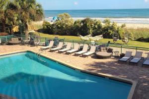 a swimming pool with lounge chairs and the beach at Making Memories in Myrtle Beach