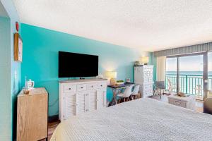 a bedroom with a large bed with a flat screen tv at Making Memories in Myrtle Beach