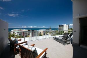 a balcony with chairs and a view of the ocean at Kings Bay Apartments in Caloundra