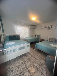 2 Betten in einem Zimmer mit grüner Bettwäsche in der Unterkunft Aquamar Oceanfront Suite 