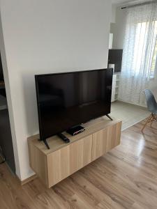 a flat screen tv on a wooden stand in a living room at Apartmán "DUNAJ" in Šamorín