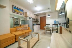 sala de estar con sofá y mesa en Comfy & Modern 1BR At Central, en Yakarta