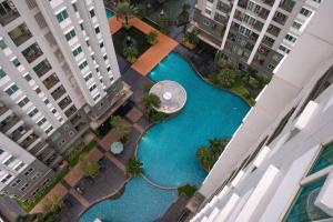 una vista aérea de una piscina en una ciudad con edificios en Comfy & Modern 1BR At Central, en Yakarta