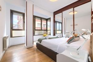 1 dormitorio con 1 cama grande y ventanas en Iturribide Hogar Moderno junto al Metro en Bilbao