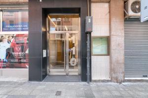 uma entrada para um edifício com uma porta giratória em Iturribide Hogar Moderno junto al Metro em Bilbao