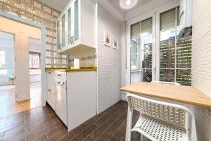 a kitchen with a wooden table and white cabinets at Iturribide Hogar Moderno junto al Metro in Bilbao