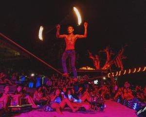 Ein Mann auf einem Seil vor einer Menge in der Unterkunft Lotus Paradise Resort - SHA PLUS in Ko Tao