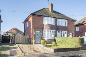 una casa de ladrillo rojo con puerta blanca en Lovely 2 Bedroom House with Parking, en Loughborough