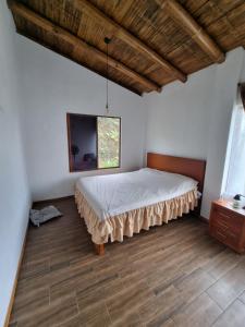 1 dormitorio con 1 cama en la esquina de una habitación en La Marujita villa de campo en Puerto Quito