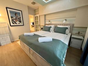 a bedroom with a large bed with two towels on it at Ground Floor Park Bestern in Szeged