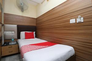 sypialnia z 2 łóżkami i drewnianą ścianą w obiekcie OYO Flagship Vivek International Hotel w mieście Dźalandhar
