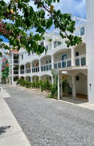 un gran edificio blanco al lado de una calle en Maho Beach Escape Luxe Studio Condo next to The Morgan Village en Maho Reef