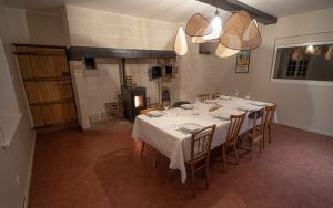 a dining room with a table and chairs and a fireplace at Domaine des Demoiselles in Hauteville