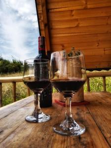 two glasses of wine sitting on a wooden table at Cabaña en La Calera Zihita in La Calera