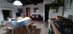 a kitchen with a table and a white table and chairs at Appartamento INTERVALLO a 5 min da Aquardens in Pescantina