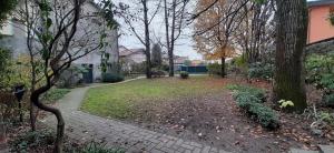 a garden with trees and a brick walkway at Appartamento INTERVALLO a 5 min da Aquardens in Pescantina +7 photos
