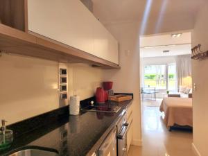a kitchen with a sink and a bed in a room at Solanas Green Park in Punta del Este