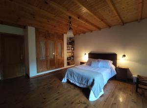 1 dormitorio con cama y techo de madera en Casa Moucheiro, en Lugo