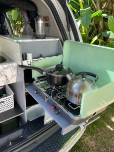 a stove with a pot and a pan on it at HW Campervan Rental NO CAMPGROUND in Hauula