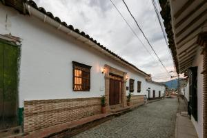 een straat in een steeg met een wit gebouw bij Casa Al Alma in Santa Fe de Antioquia