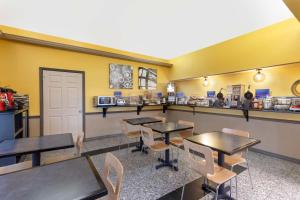 a dining room with tables and chairs and a counter at Best Western West Monroe Inn in West Monroe