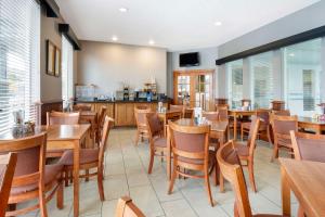 a restaurant with wooden tables and chairs and windows at Best Western Wheatland Inn in Colfax