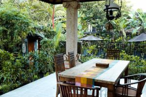 een houten tafel en stoelen op een patio bij Spacious 1bd Villa Suite in Penestanan in Ubud