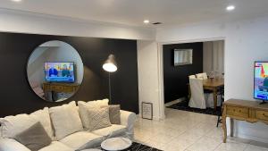 a living room with a white couch and a mirror at Luxury Fitzroy House in Melbourne