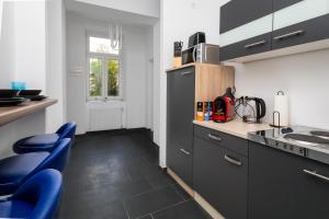 a kitchen with black cabinets and blue chairs at Danube family deluxe retreat in Vienna