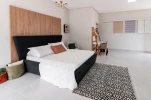 um quarto com uma cama grande e um tapete em Flat Design Amplo na Zona Sul prox ao UMC em Uberlândia