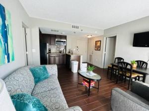 a living room with a couch and a table and a kitchen at 2BR Condo 1 mile from Universal in Orlando