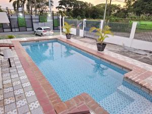 a swimming pool in a yard with a car at Express Inn PTY Aeropuerto Internacional Panama in Tocumen