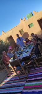 a group of people sitting at a picnic table at AUBERGE SAHARA IRIKI & Désert Tours in Foum Zguid
