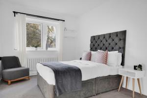 a bedroom with a large bed and a chair at Peckham apartments by APS in London