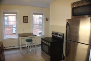 a kitchen with a stainless steel refrigerator and a stool at Historic West End Gem in Hartford
