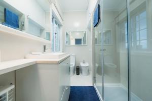 uma casa de banho com 2 lavatórios e uma cabina de duche em vidro. em Douro Garden & Rooftop - Authentic Portuguese Guesthouse em Vila Nova de Gaia