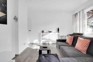 a white living room with a couch and a table at Peckham apartments by APS in London