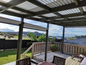 eine Pergola auf einer Terrasse mit zwei Stühlen in der Unterkunft Modern House near Motuoapa Tongariro Crossing fishing skiing in Turangi