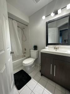 a bathroom with a toilet and a sink and a mirror at Cozy-2bedroom in Oakville in Oakville