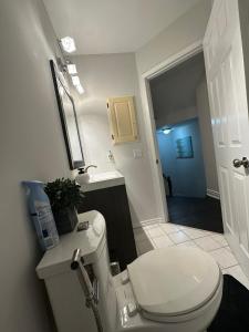 a bathroom with a white toilet and a hallway at Cozy-2bedroom in Oakville in Oakville