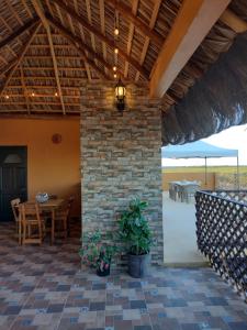 een patio met een stenen muur en een tafel en stoelen bij Hotel Prado´s in San Carlos