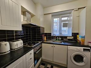 cocina con fregadero y lavadora en Globe Rooms, en Londres